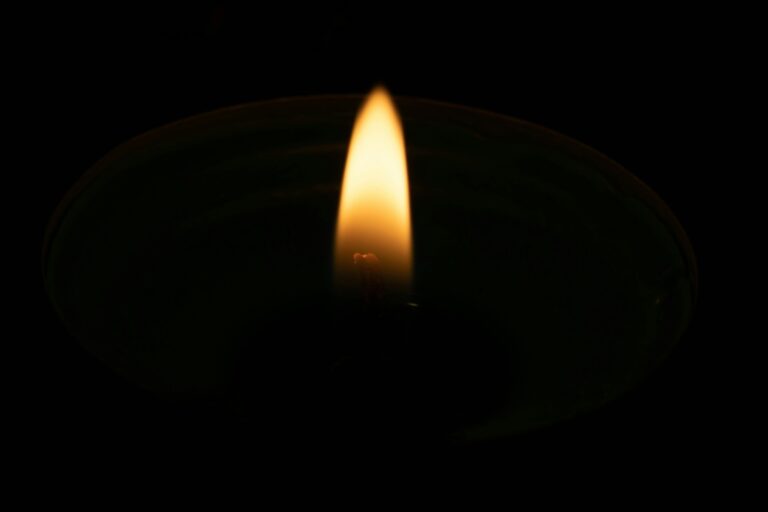 A single candle flame in darkness — featured image for UPSC Mains essay topic In an age of abundance, the rarest commodity is attention