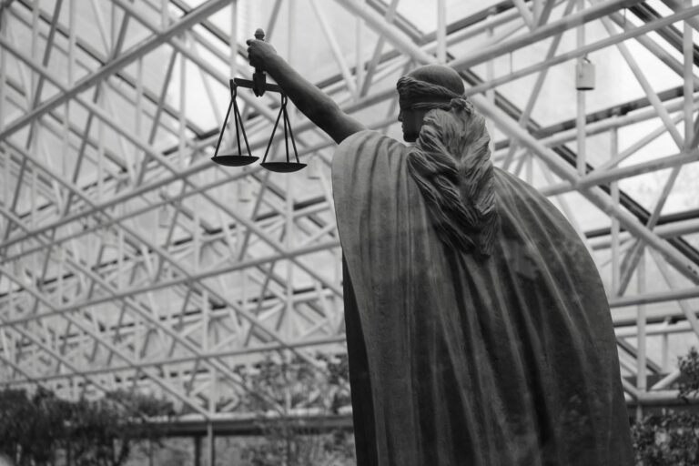 Statue of Lady Justice holding scales — UPSC Mains essay topic A society that has more justice is a society that needs less charity
