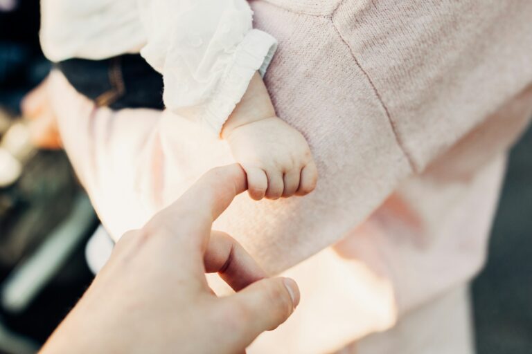 A small child's hand grasps an adult finger — UPSC Mains essay topic The Hand That Rocks the Cradle Rules the World