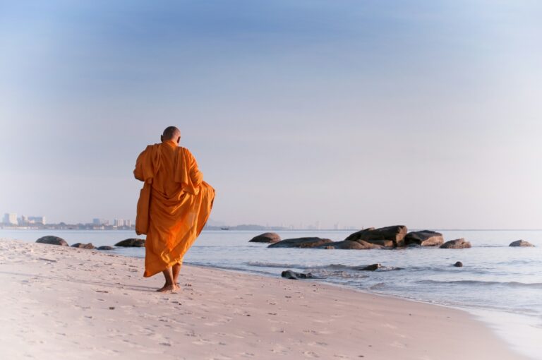 Buddhist monk in saffron robe walking at dawn — UPSC Mains essay topic Philosophy of wantlessness is utopian while materialism is a chimera