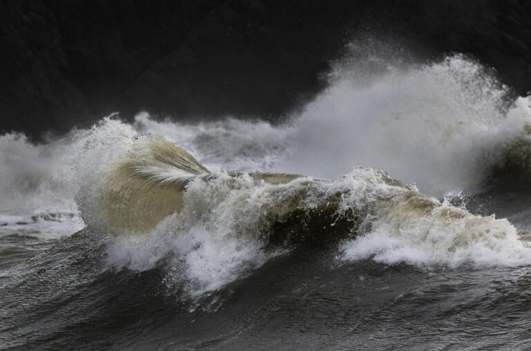 Powerful ocean waves crashing during a storm — UPSC Mains essay topic Ships Do Not Sink Because of Water Around Them but Water Inside Them