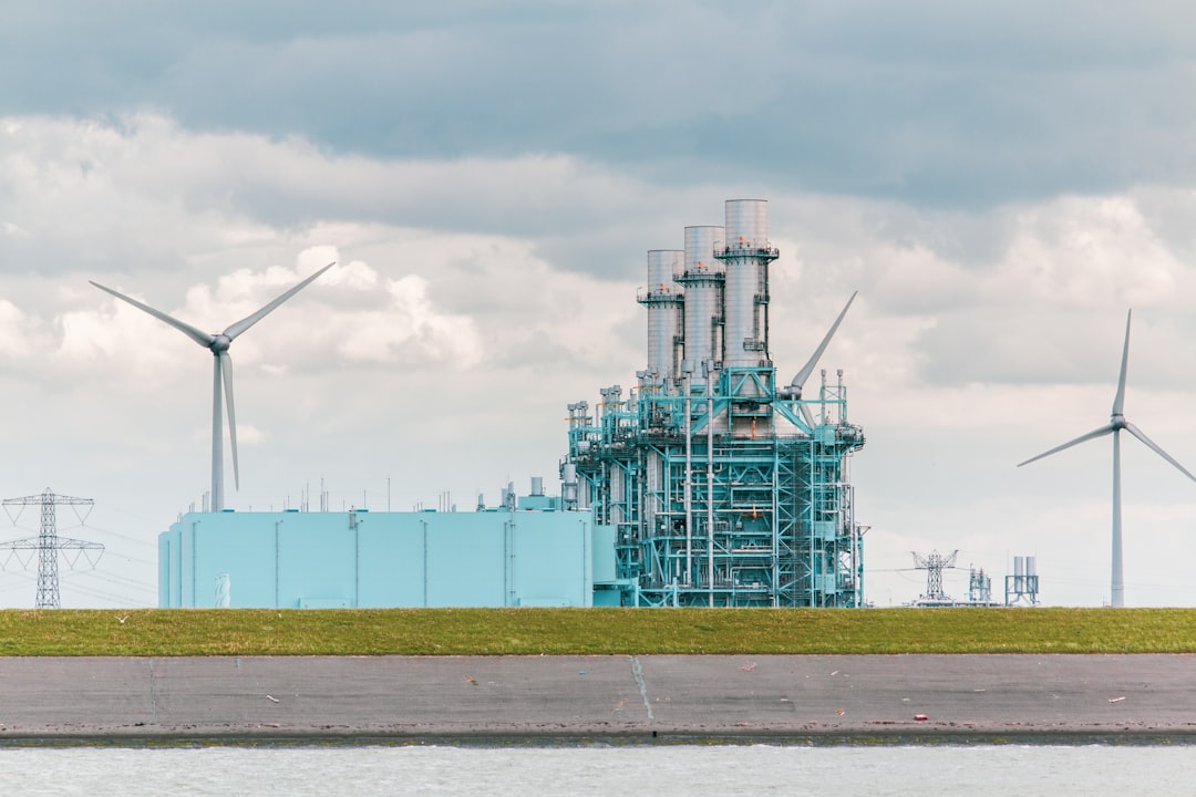 A modern hydrogen-production plant beside wind turbines and solar panels