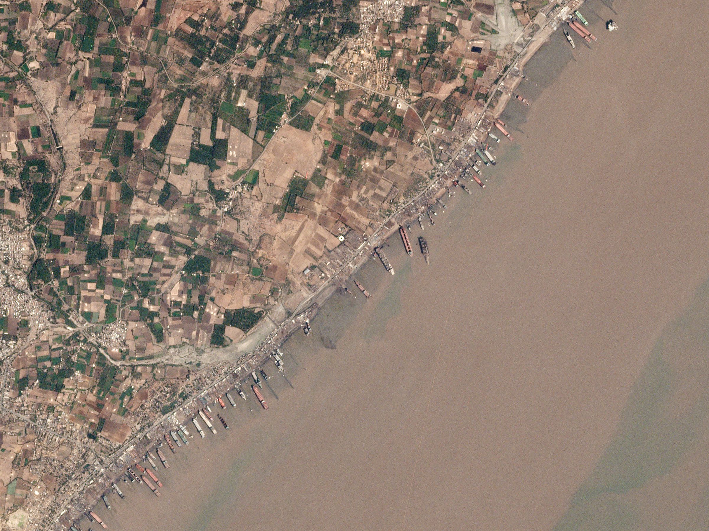 Beached cargo vessels being dismantled at a tidal ship-recycling yard