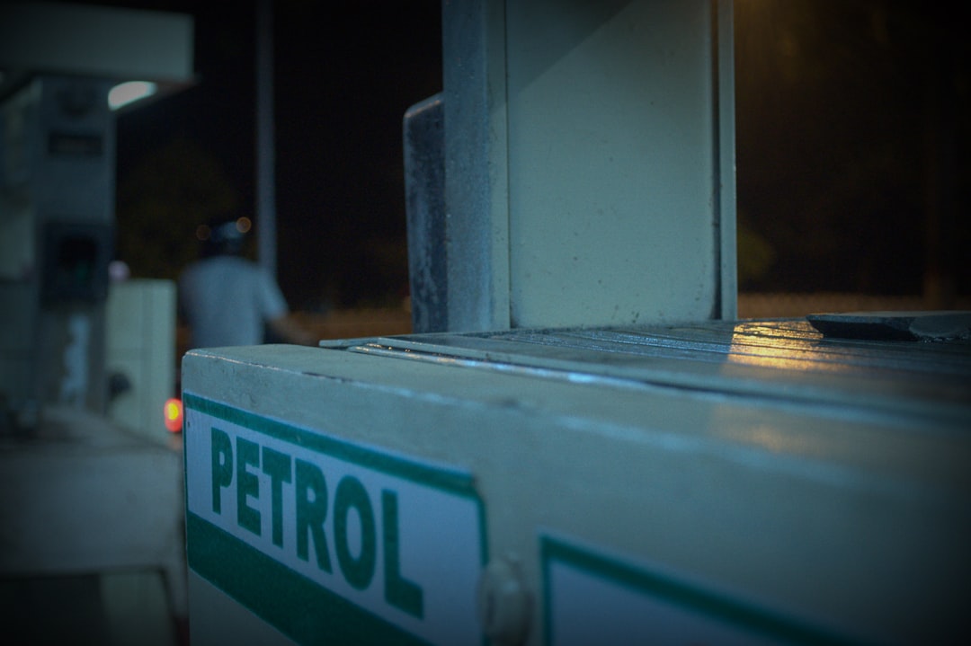 Fuel nozzle at a petrol pump dispensing blended petrol into a car