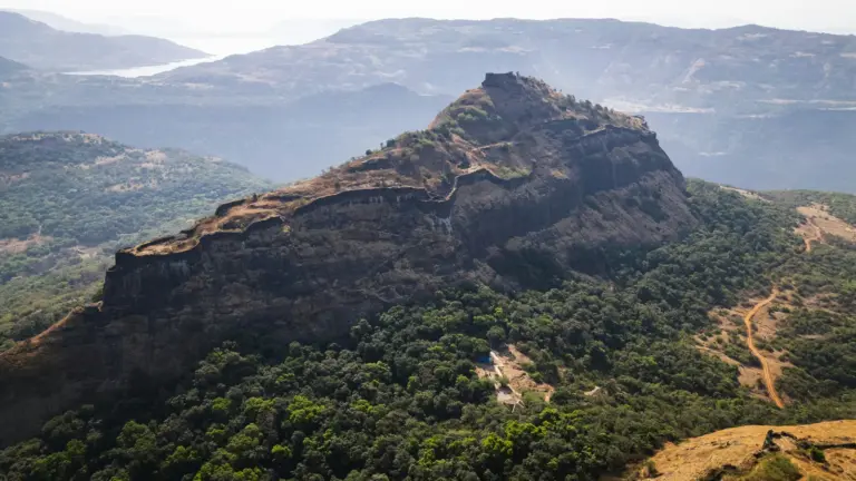 A hill fort's stone ramparts climbing a rocky outcrop