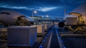 Secured air cargo containers transferring between domestic and international aircraft at an airport hub