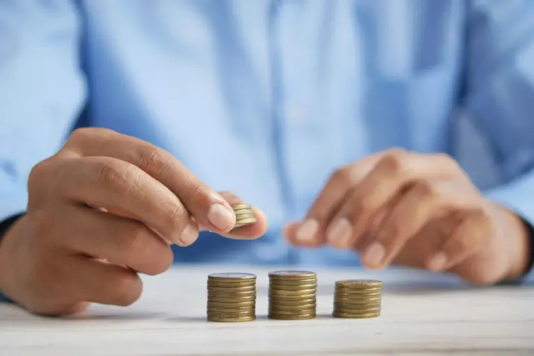 Stacked coins beside a savings passbook