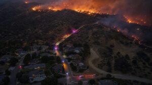 Wind-driven wildfire approaching homes at a wildland-urban interface
