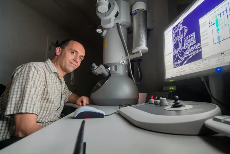 A researcher working at an electron microscope