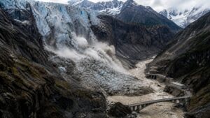 Glacial ice and rock collapsing into a narrow Himalayan river gorge and generating a debris-laden downstream surge