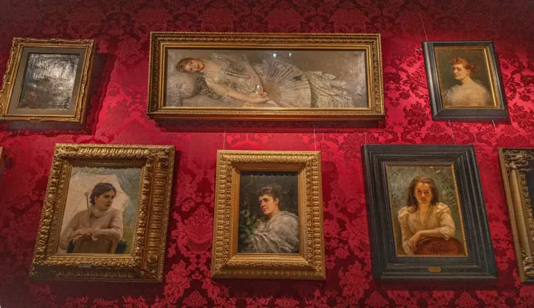 Framed oil paintings hung along a gallery wall