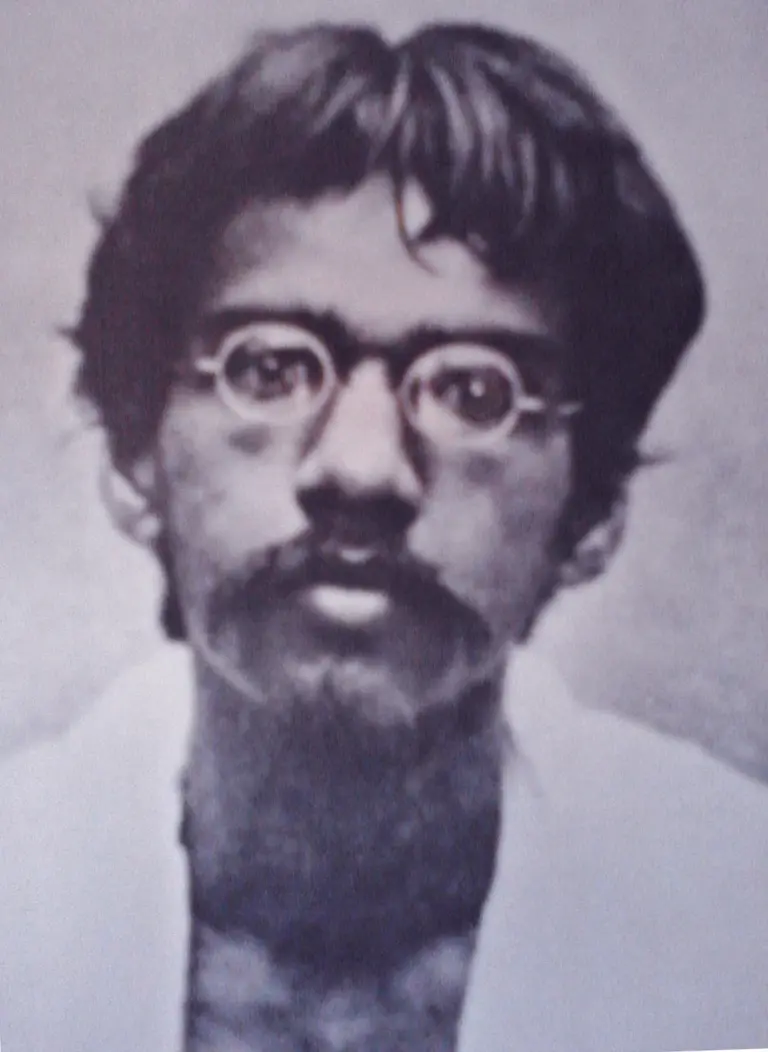 Portrait of Bengal revolutionary Barindra Kumar Ghosh as a young man with round spectacles, tousled hair and a beard