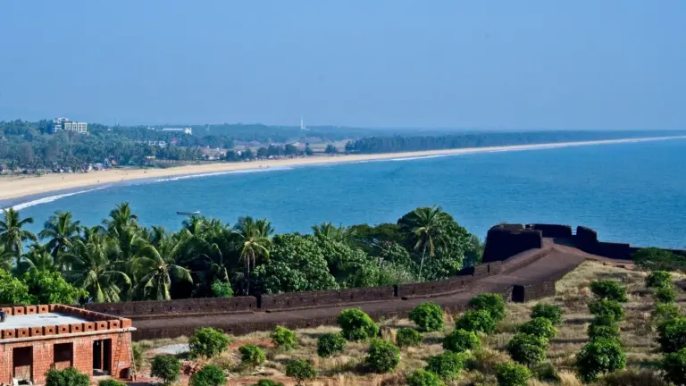 Laterite ramparts of Bekal Fort curving above palm groves and a long sandy beach in Kasaragod, Kerala
