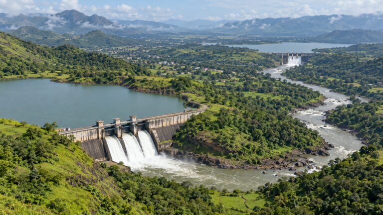 Illustrative two reservoir dams and connecting river valley in green hilly terrain