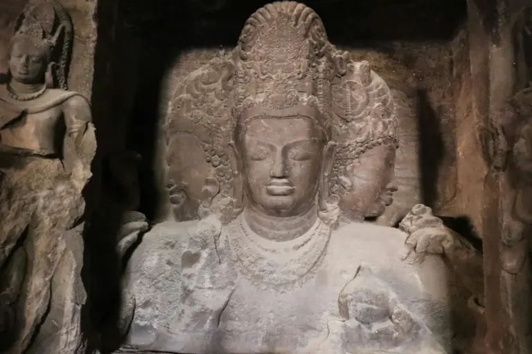 The three-headed Trimurti sculpture of Shiva carved into the rock inside the main Elephanta cave