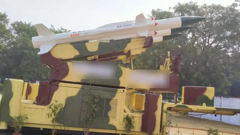 An Akash surface-to-air missile launcher with three missiles, on display in Hyderabad; its two display placards are blurred