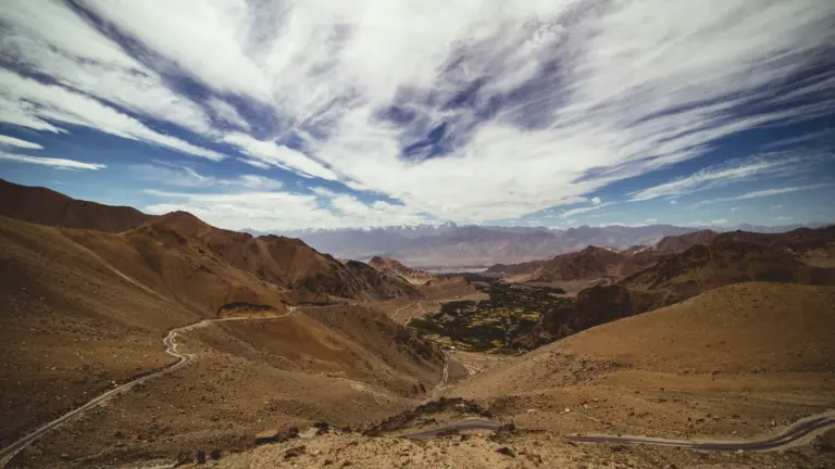 Switchback road climbing towards Khardung La across barren slopes above the Leh valley, Ladakh