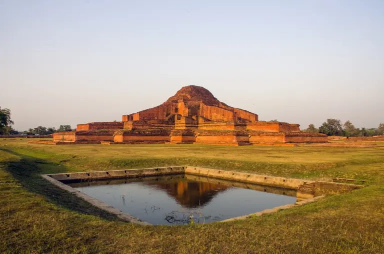 The terraced brick central shrine of Somapura Mahavihara at Paharpur, Bangladesh, reflected in a square tank in low sunlight