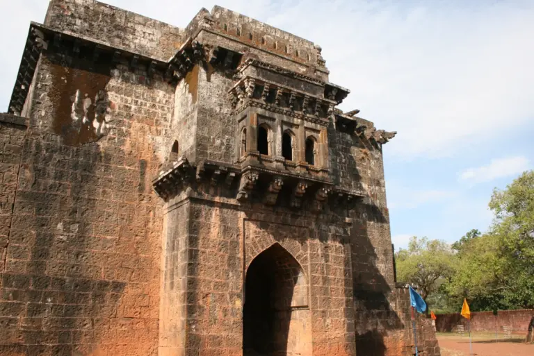 A stone gateway at Panhala fort near Kolhapur, its pointed arch topped by a carved projecting balcony
