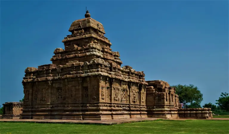 A Chalukya-era stone temple with a Dravidian-style tower on the lawns of Pattadakal, Karnataka