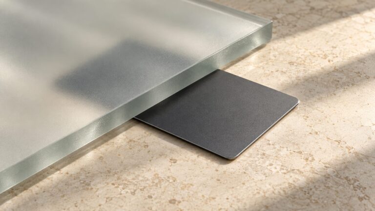 Conceptual still life of a plain bank card beneath frosted glass on a stone counter