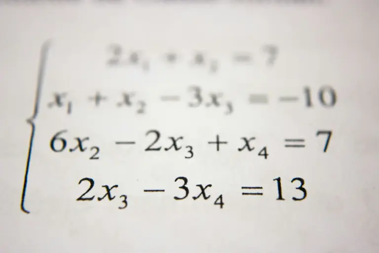 A system of linear equations printed in black ink on white paper. Photo by Antoine Dautry on Unsplash via Unsplash.