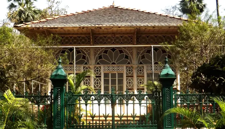 Upasana Griha, the glass-walled prayer hall at Santiniketan, behind ornamental green railings
