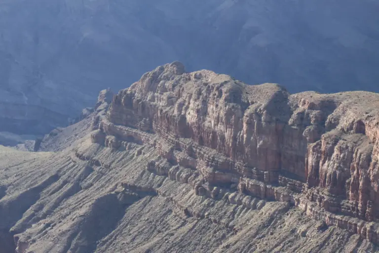 Layered rock formations in a vast canyon. Photo by Alban on Unsplash via Unsplash.