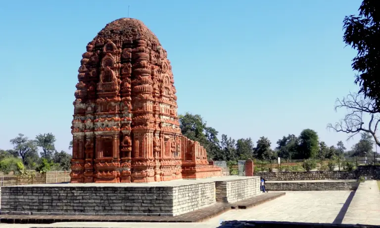 The brick Lakshmana temple at Sirpur, Chhattisgarh, its carved curved tower rising above a stone plinth under a blue sky