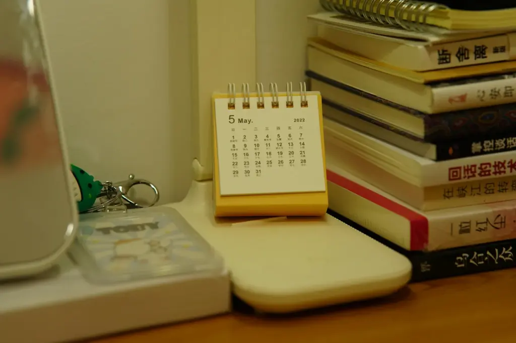 Desk calendar beside a stack of books