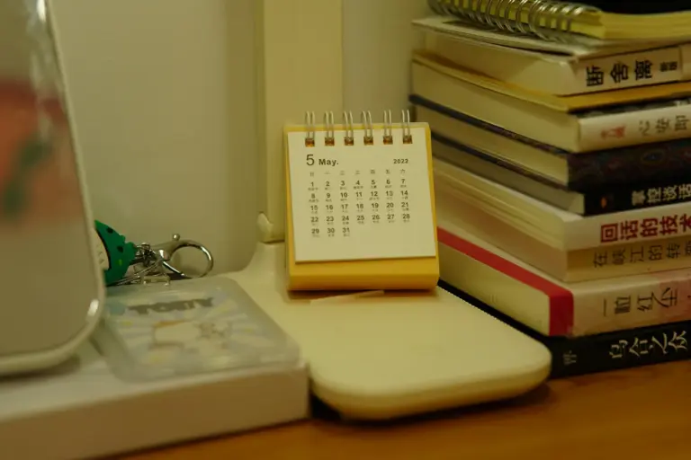 Desk calendar beside a stack of books