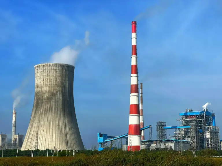 Coal-fired thermal power station with a red and white chimney and a cooling tower near Vijayawada, Andhra Pradesh