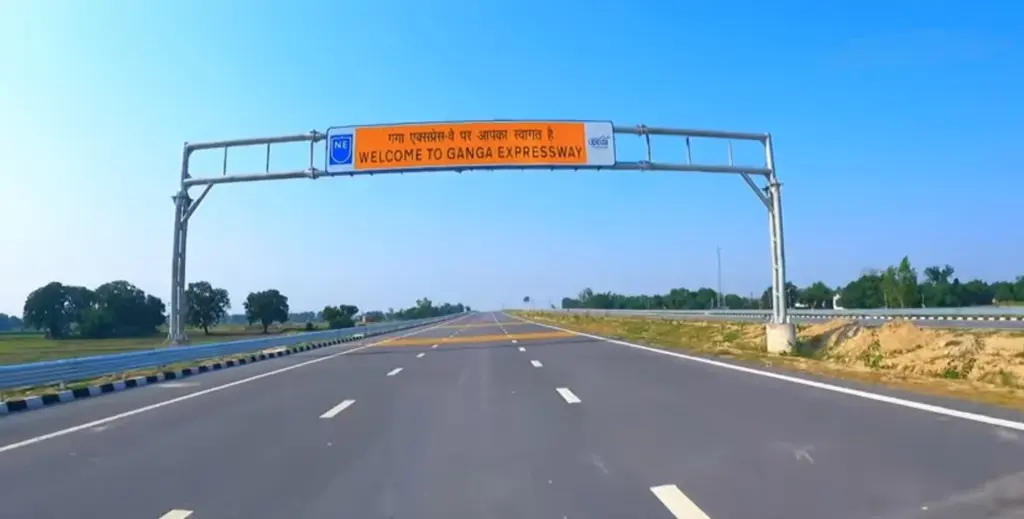 An overhead gantry sign reading Welcome to Ganga Expressway spans an empty six-lane carriageway near Prayagraj.
