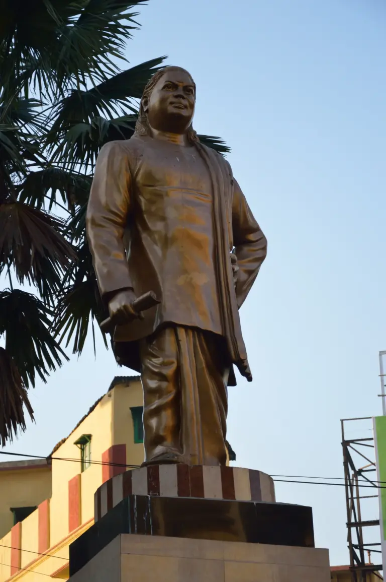 Bronze statue of Pasumpon Muthuramalinga Thevar holding a rolled scroll, on a pedestal in Kolkata.